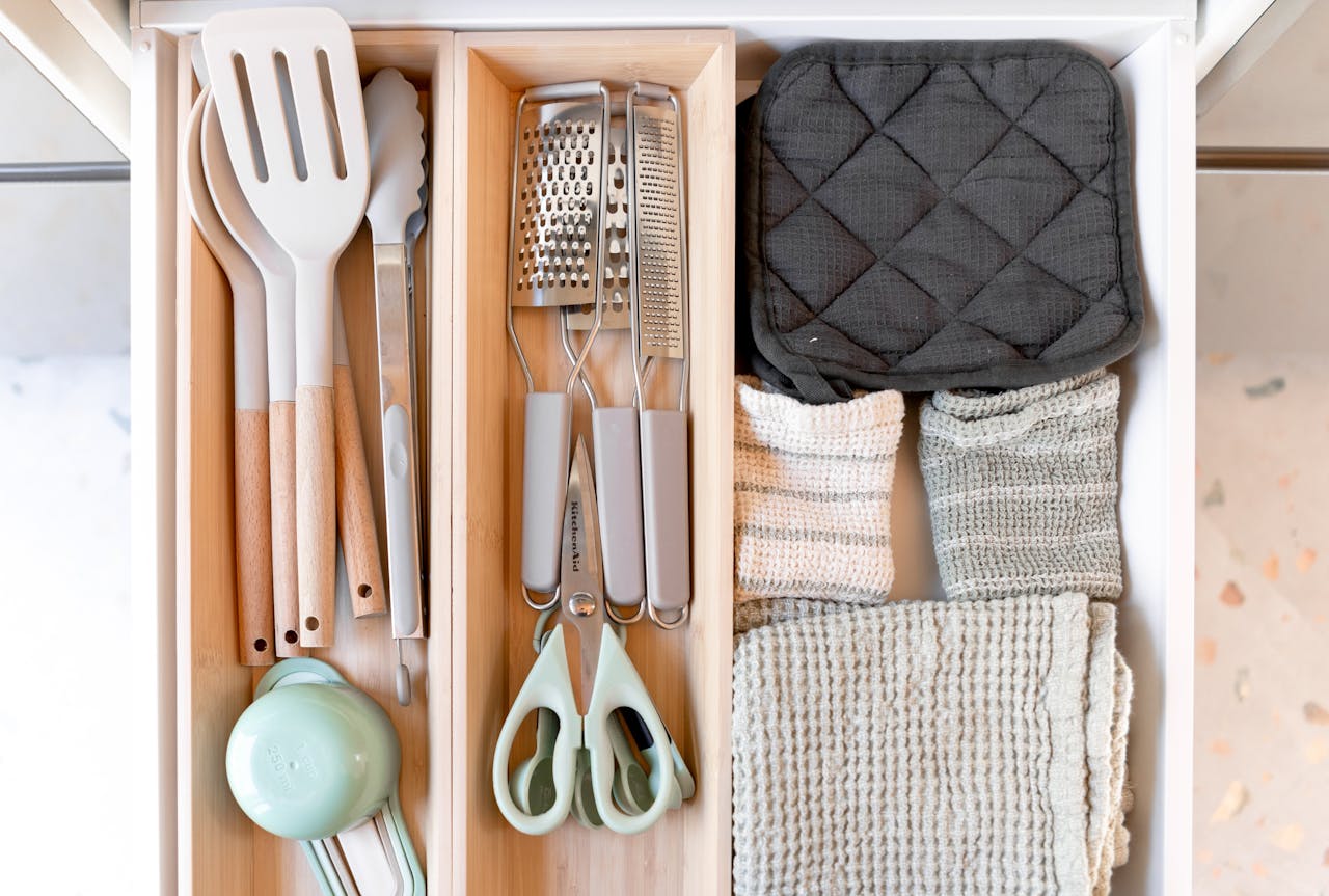 Neatly arranged kitchen tools and textiles in a drawer, showcasing an organized culinary space.